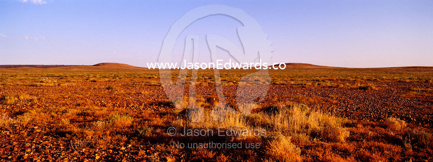 Sunset descends over the scorching Gibber Plains of the open desert. Sturt National Park, New South Wales, Australia.