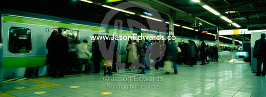 Crowds of commuters fight to board a train at Ikebukuro Station. Ikebukuro Station, Tokyo, Japan.