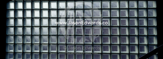 Daylight seeps through a glass brick wall in a museum stairwell. Tokyo Metropolitan Museum of Photography, Japan.