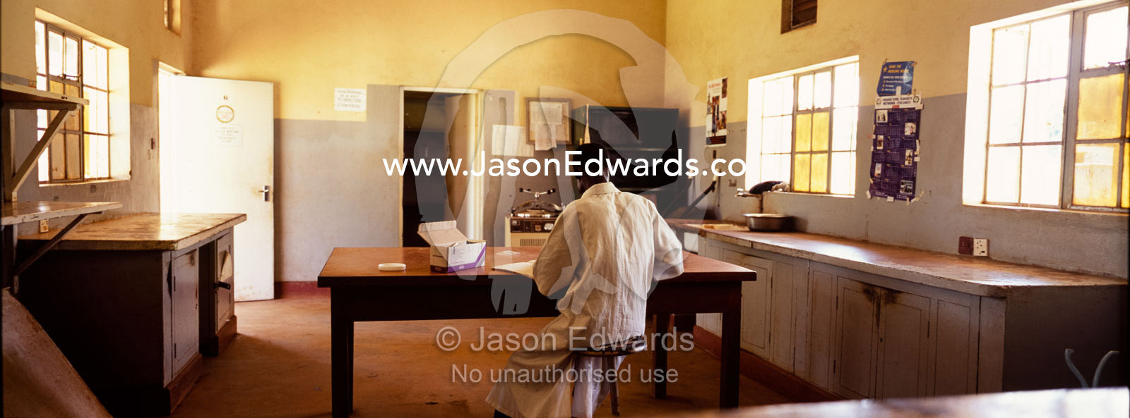 A medical technician in a barren clinic dispenses HIV AIDS medication. Tororo District Hospital, Uganda.