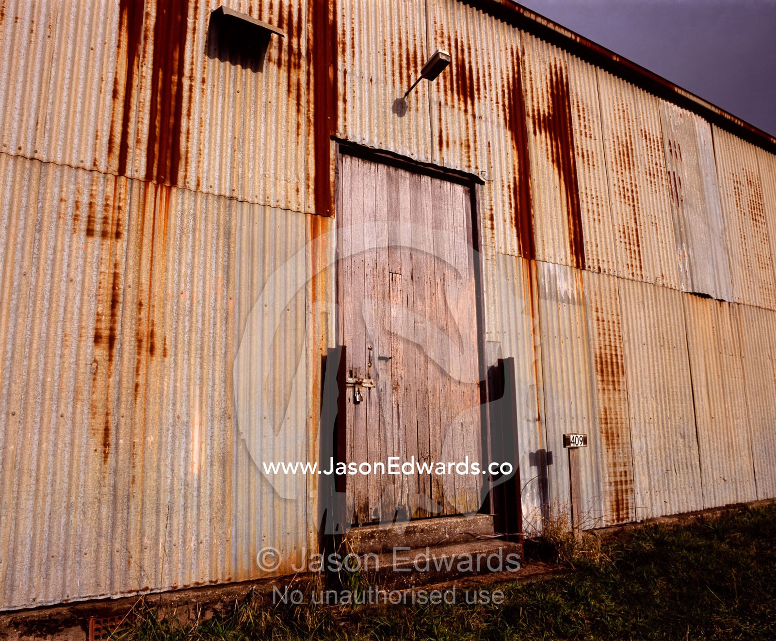 Rust eats away at a corrugated tin shed wall on a farm in Tasmania. near Ridgley, Tasmania, Australia.