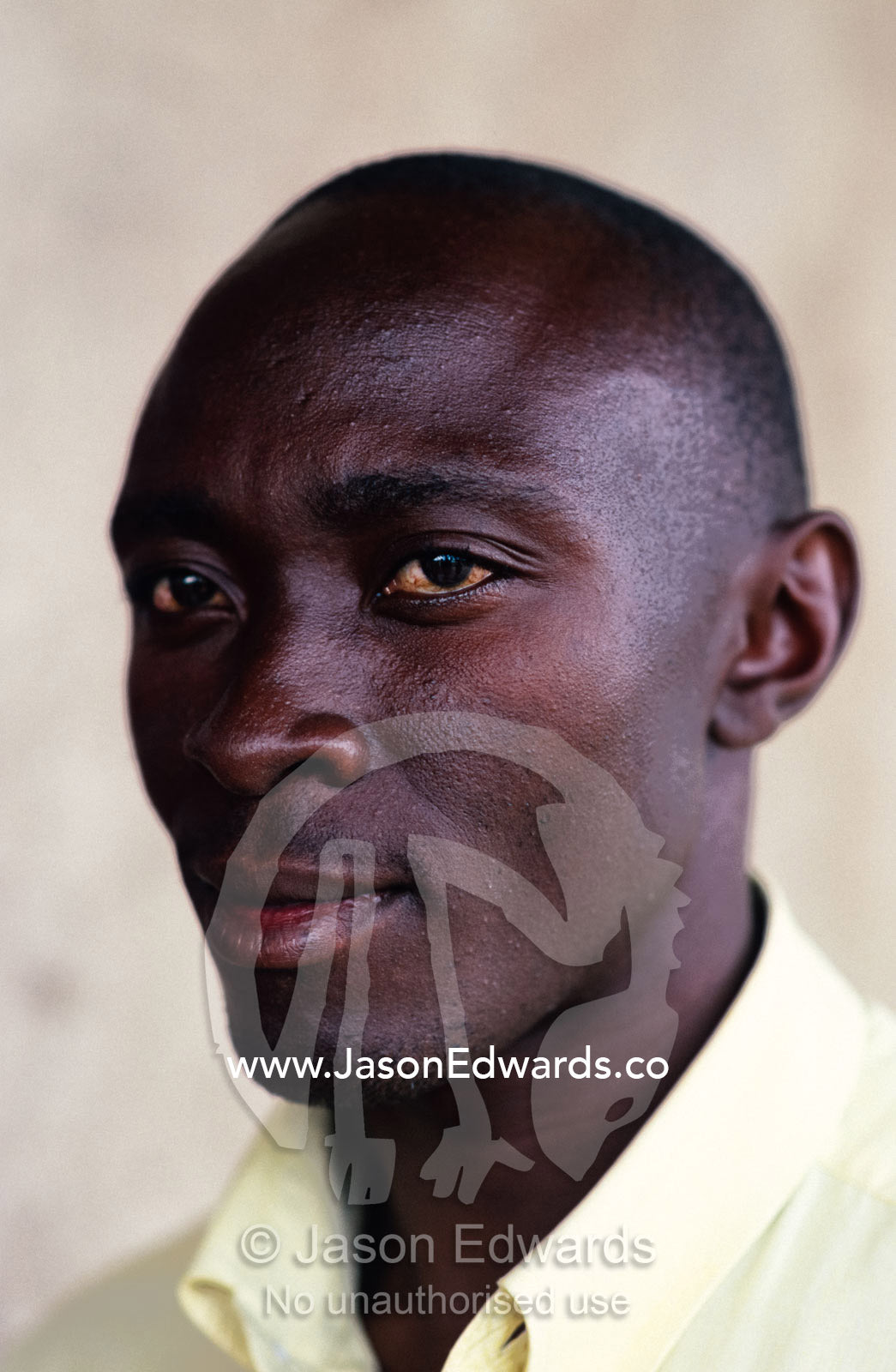 A portrait of an East African man in a business shirt. Tororo District, Uganda.