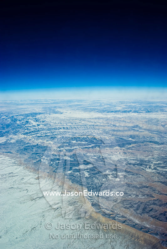 A high altitude view of rugged desert mountain ranges covered in snow. South West United States of America.