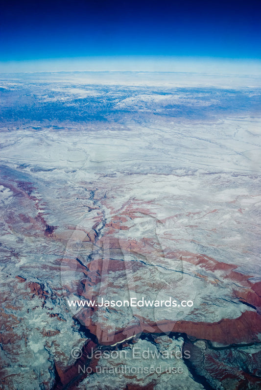 A high altitude view of rugged desert mountain ranges covered in snow. South West United States of America.