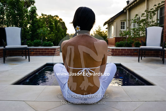 A model sits by a spa in an architecturally design suburban garden. Hawthorn, Victoria, Australia.