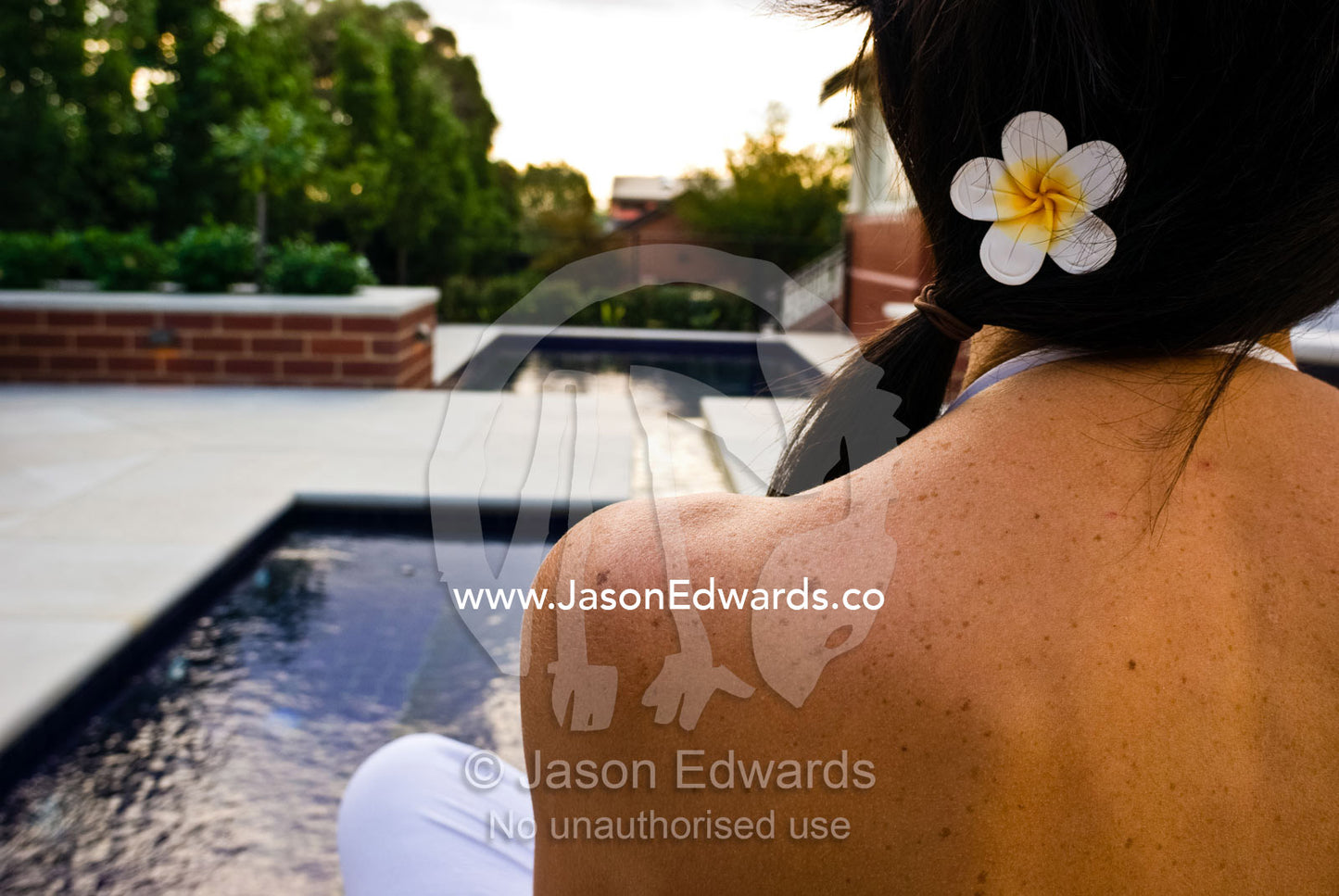 A model sits by a spa in an architecturally design suburban garden. Hawthorn, Victoria, Australia.