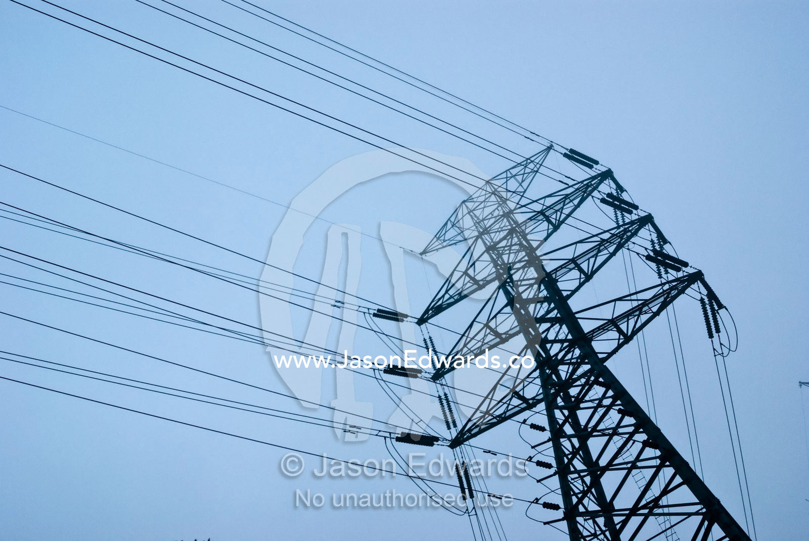 A large electricity tower and power cables on a foggy morning. Point Cook, Victoria, Australia.