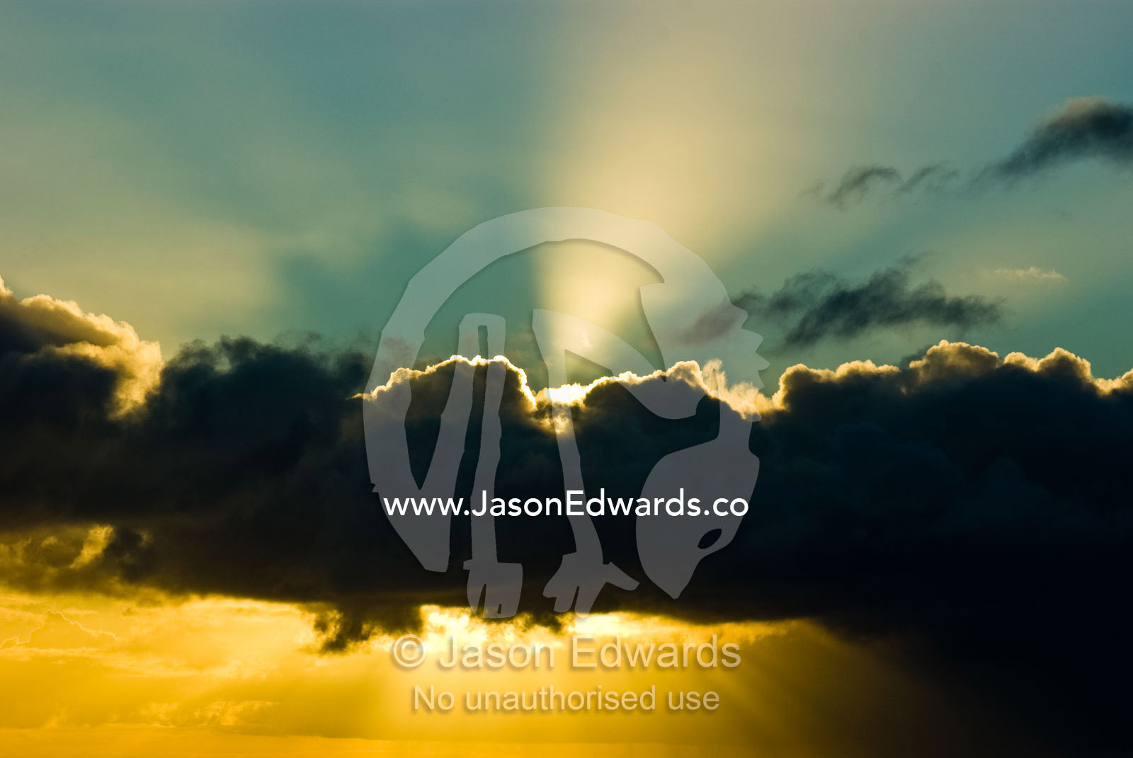 The setting sun pierces ominous clouds from a winter storm front. Bass Strait, Victoria, Australia.