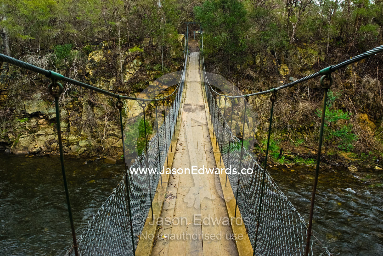 A suspension bridge assists hikers to cross the Ovens River canyon. Ovens River, Bright, Victoria, Australia.