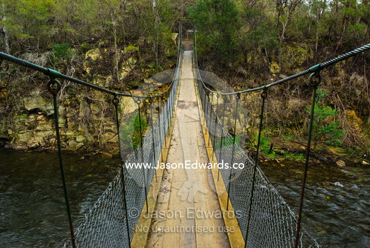 A suspension bridge assists hikers to cross the Ovens River canyon. Ovens River, Bright, Victoria, Australia.