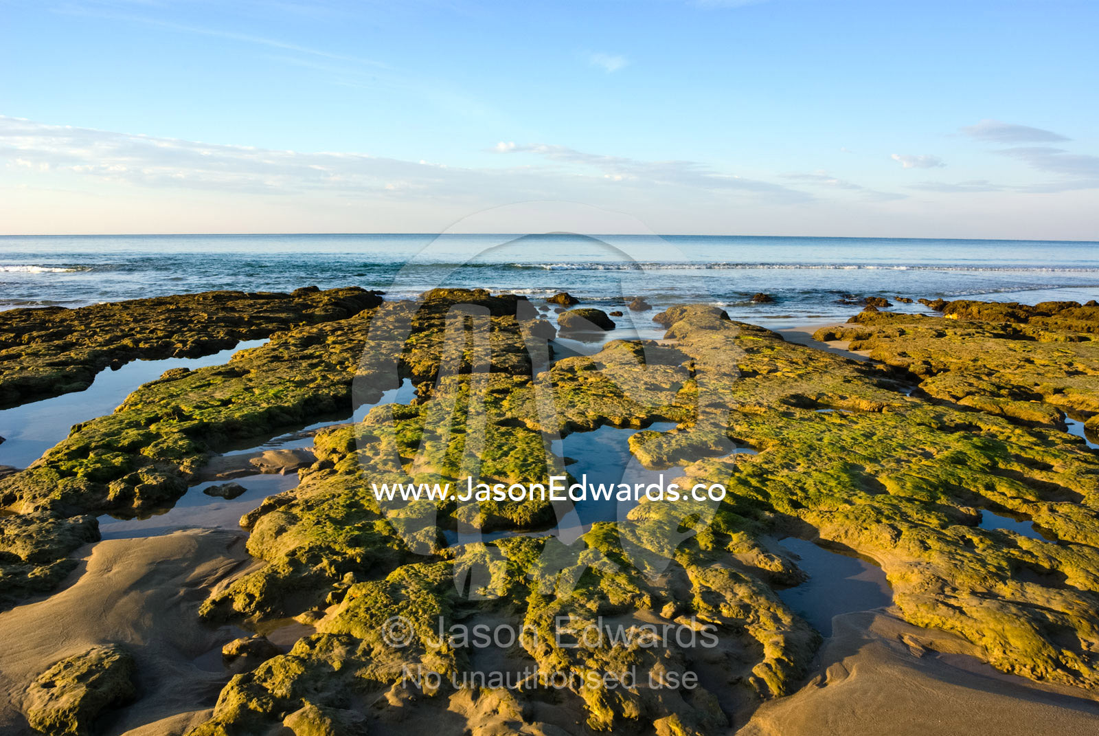 Dawn illuminates rocks and tidal pools exposed at low tide. Point Danger, Torquay, Victoria, Australia.