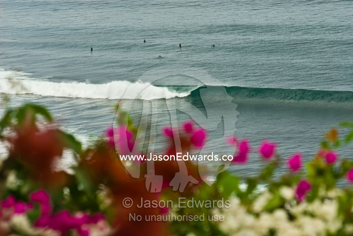 Surfers line the swell at Impossibles a break on the Bukit Peninsula. Bukit Peninsula, Bali, Indonesia.