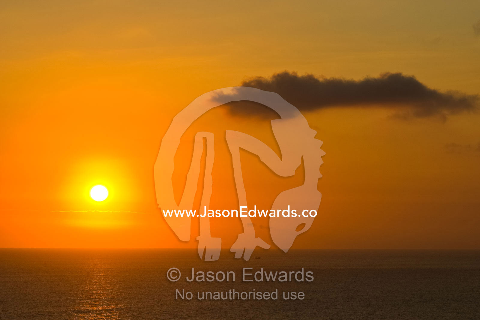 A flaming tropical island sunset over the seas of the Bali Strait. Bukit Peninsula, Bali, Indonesia.