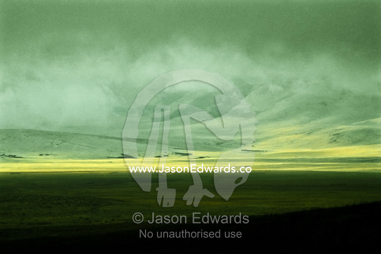 Mist shrouds a vast savannah plain hiding distant mountain peaks. Ngorongoro Conservation Area, Tanzania.