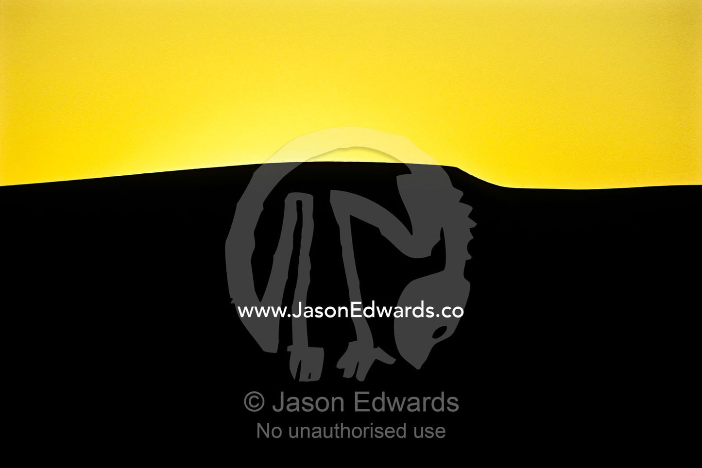 The silhouette of a vast sand dune crest against a vivid yellow sky. near Sossusvlei, Great Southern Dune Field, Namib-Naukluft National Park, Namibia