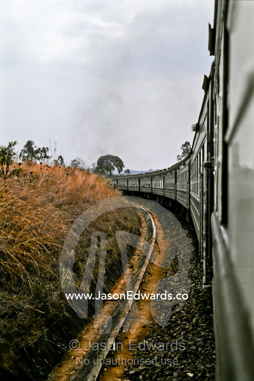 Carriages from the famous Blue Train curve around a bend in the track. Southern Tanzania.