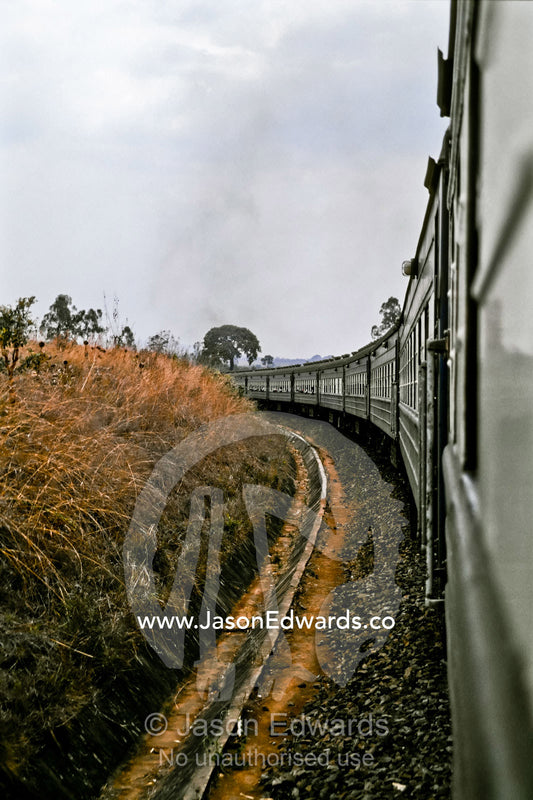 Carriages from the famous Blue Train curve around a bend in the track. Southern Tanzania.