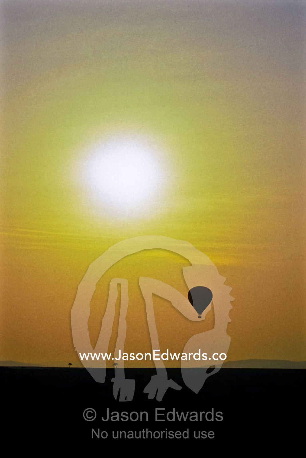 A hot air balloon hovers above a vast savannah plain at dawn. Masai Mara Reserve, Kenya.