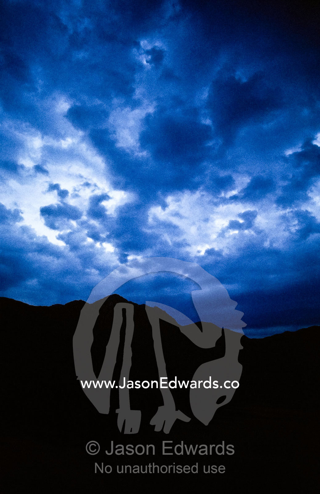 Dark, sinister storm clouds roil over a mountain range at night. South West Wilderness, Southwest National Park, Tasmania, Australia.