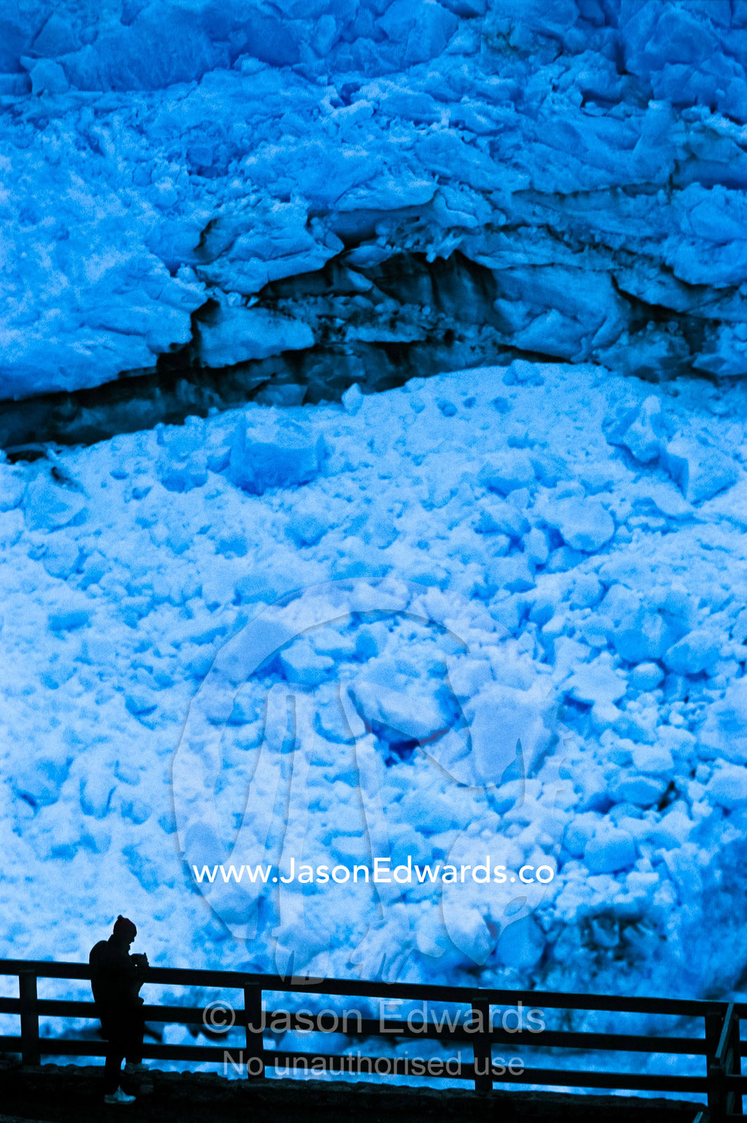 A tourist dwarfed by the fracture zone of the Perito Moreno Glacier. Los Glaciares National Park, Parque Nacional Los Glaciers, Patagonia, Santa Cruz Province, Argentina.
