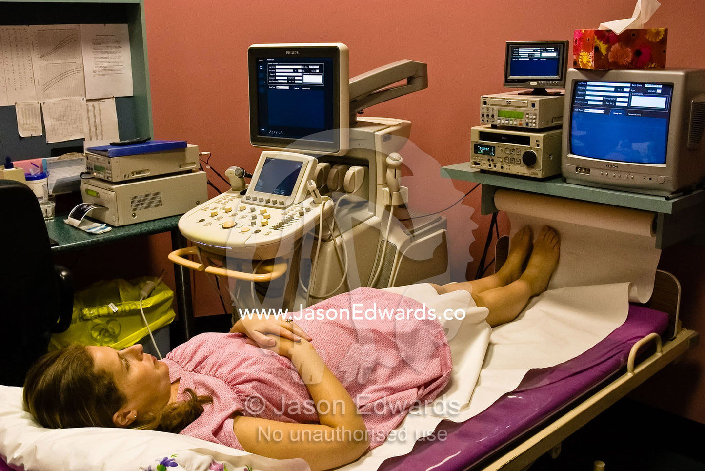 A young pregnant woman waiting for an ultrasound in a medical clinic. East Melbourne, Victoria, Australia.
