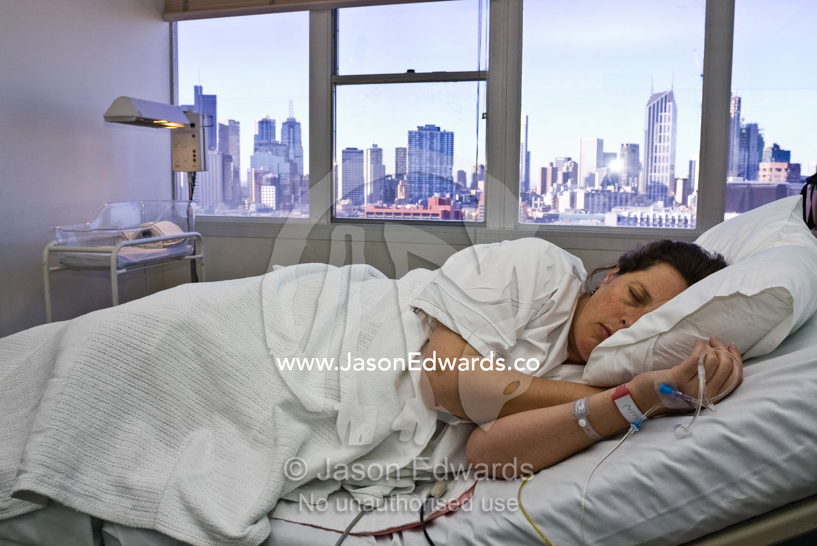 A pregnant woman sleeps between labor contractions in a city hospital. Frances Perry House, Carlton, Victoria, Australia.