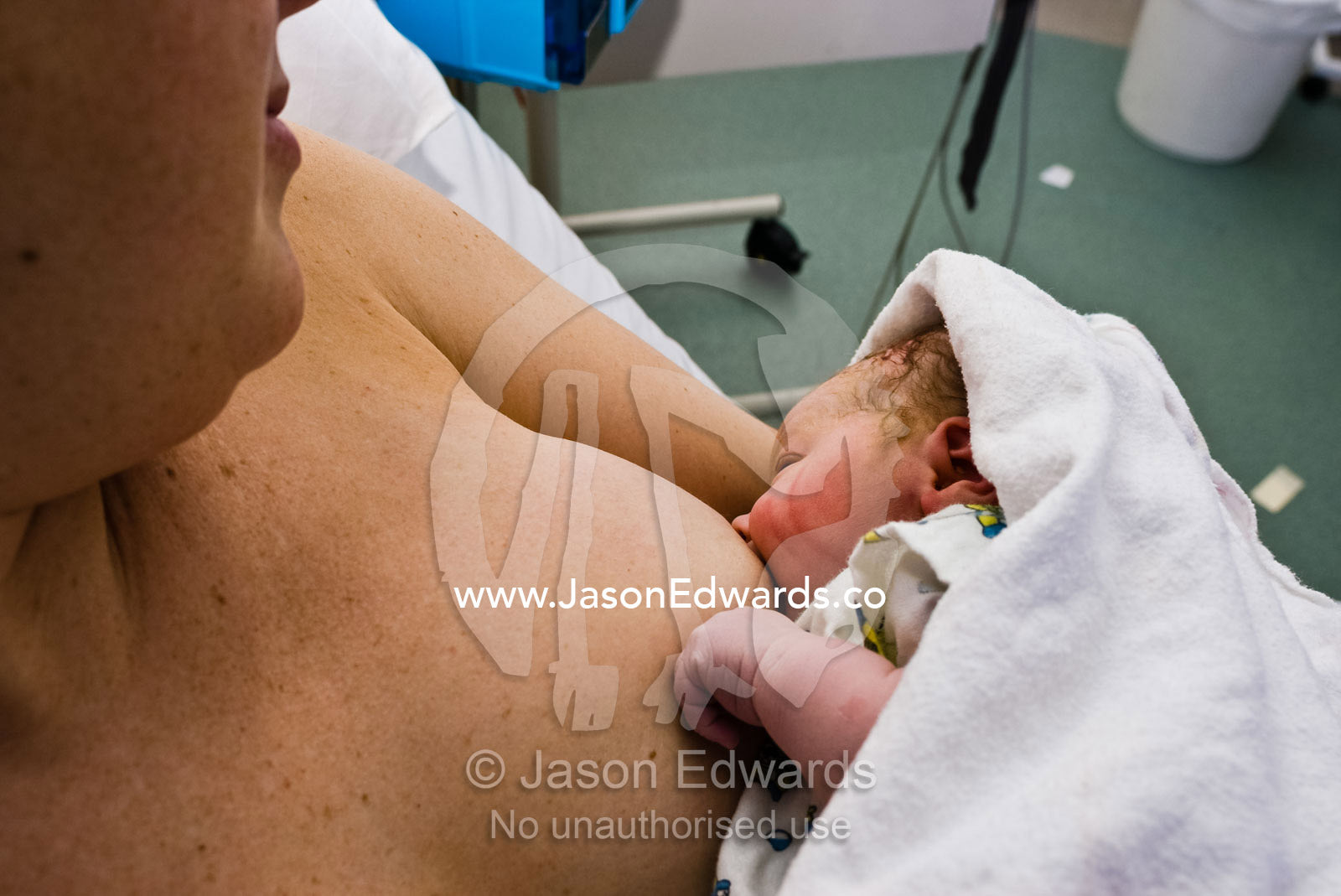 A newborn baby suckles from his mother's breast for the first time. Frances Perry House, Melbourne, Victoria, Australia.