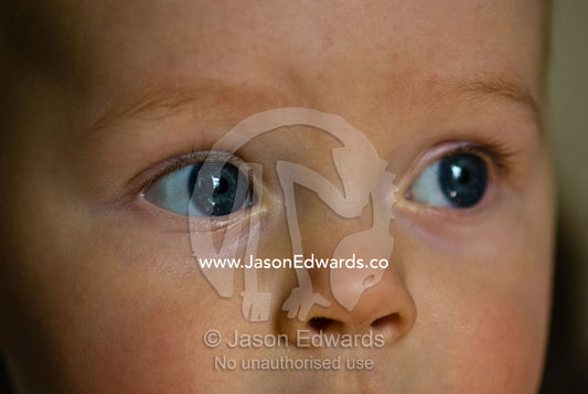 The clear, bright blue eye and button nose of an innocent baby boy. Collingwood, Victoria, Australia.