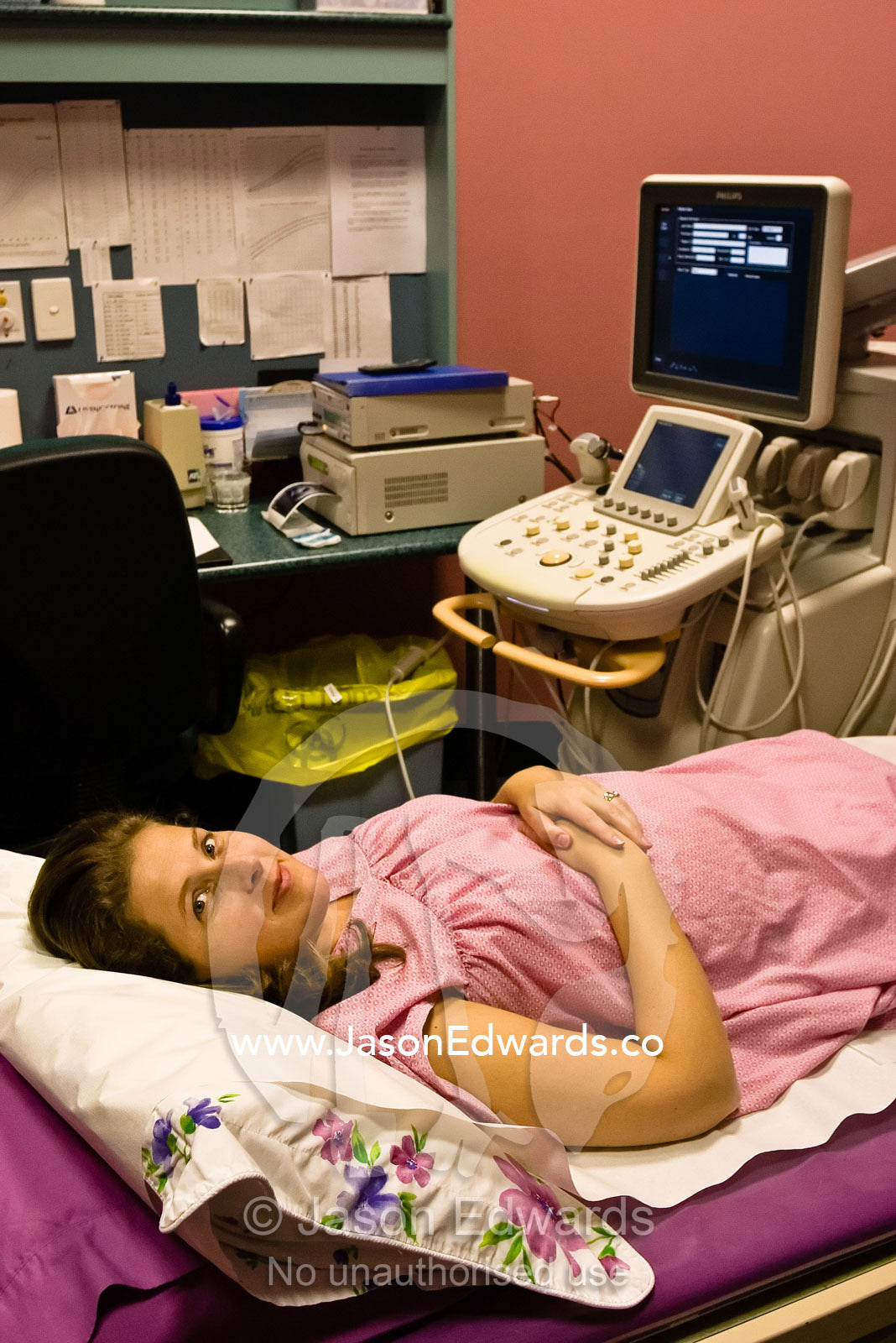 A young pregnant woman waiting for an ultrasound in a medical clinic. East Melbourne, Victoria, Australia.