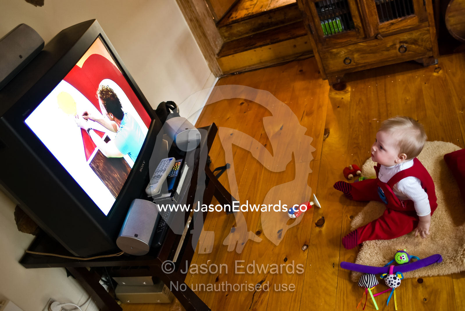 A baby sits transfixed by a character on a children's television show. North Carlton, Victoria, Australia.