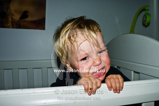 A crying and distressed young boy refuses to go to sleep in his cot. Carlton North, Victoria, Australia.