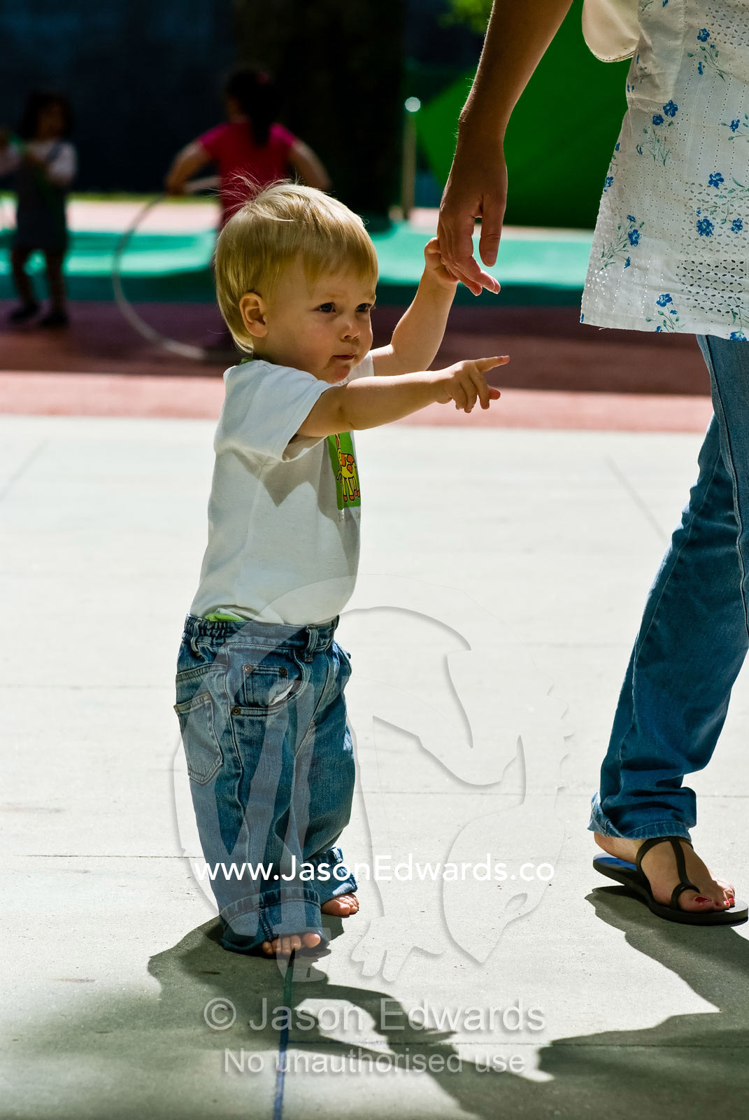 A young boy gives his mother distinct directions in a playground. Museum Victoria, Carlton, Victoria, Australia.