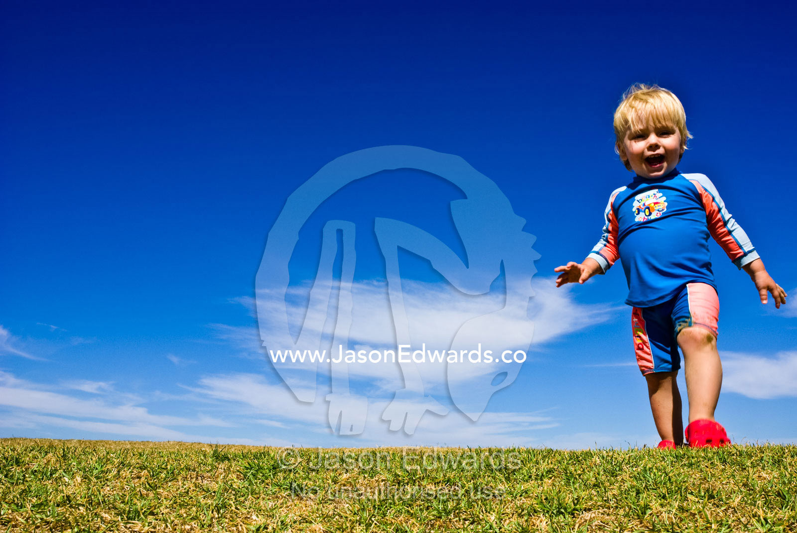 A baby proudly crests a hill beneath a blue sky on a summer day. Torquay Point, Torquay, Surf Coast, Victoria, Australia.