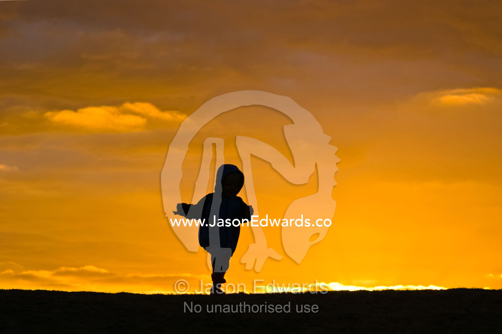 A sure-footed toddler proudly runs across the horizon at sunrise. Torquay, Victoria, Australia.