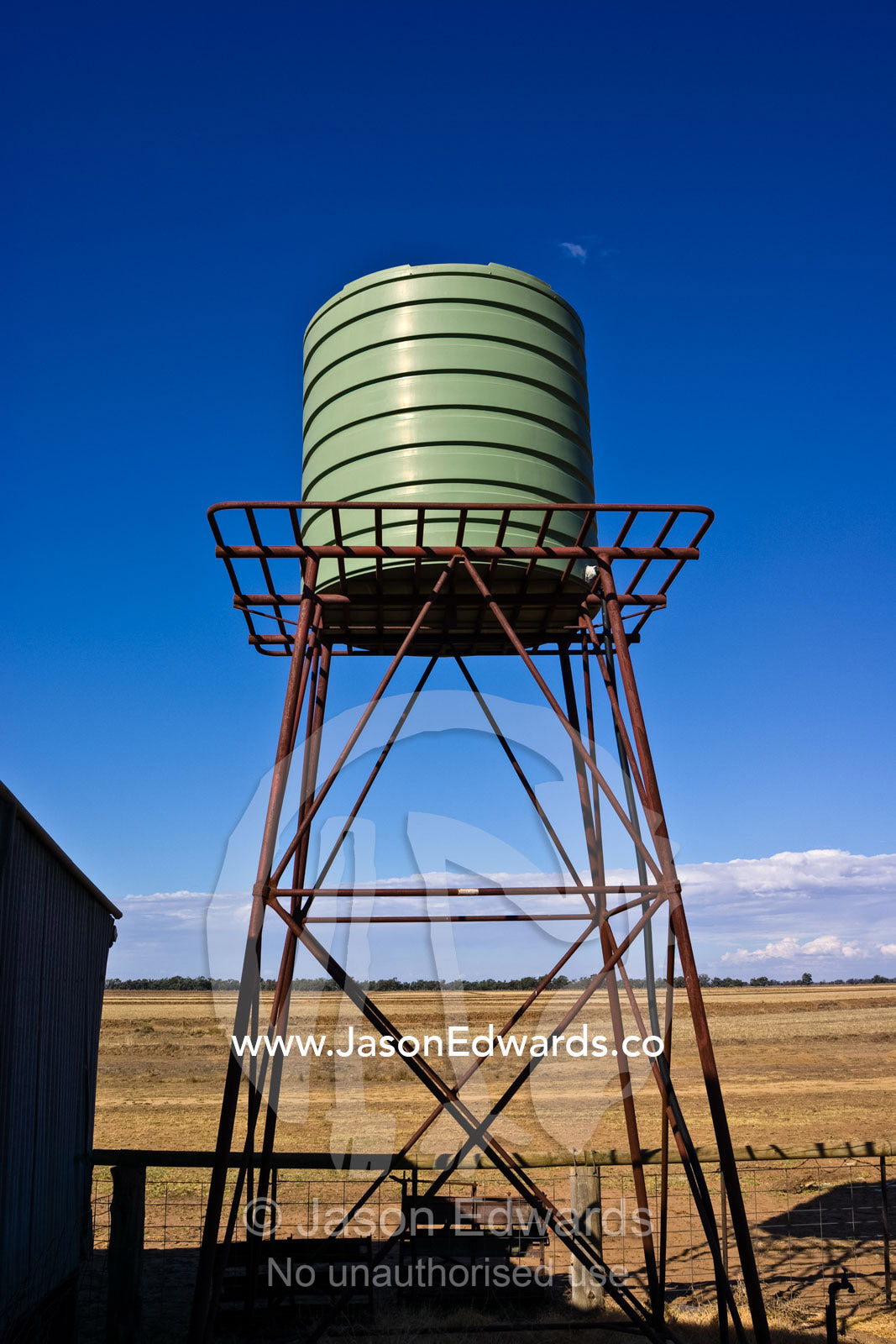 A large tank provides water for sheep on a drought-stricken farm. Mundiwa Station, Deniliquin, New South Wales, Australia.