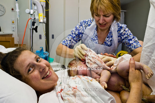 An obstetric nurse cleans a newborn baby immediately after birth. Frances Perry House, Melbourne, Victoria, Australia.