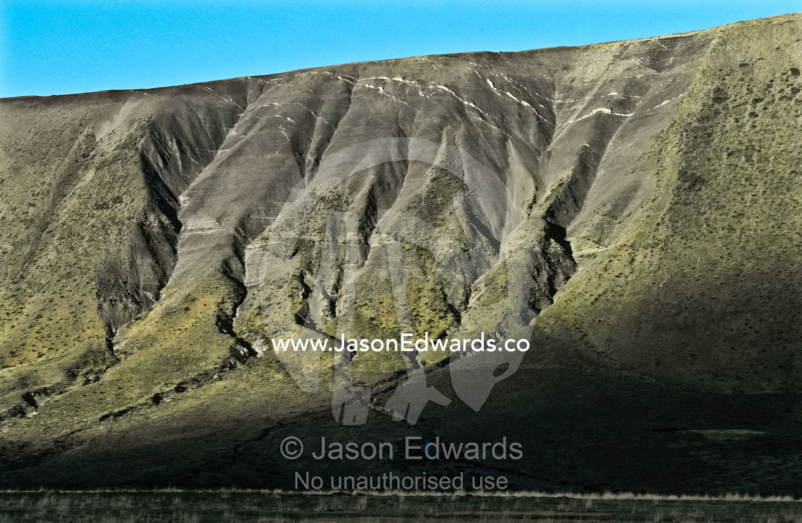 Over millenia snow, ice and rain have eroded steep mountain slopes. Chilean Altiplano north of Punta Arenas, Chile.