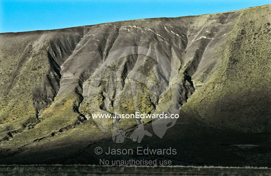 Over millenia snow, ice and rain have eroded steep mountain slopes. Chilean Altiplano north of Punta Arenas, Chile.