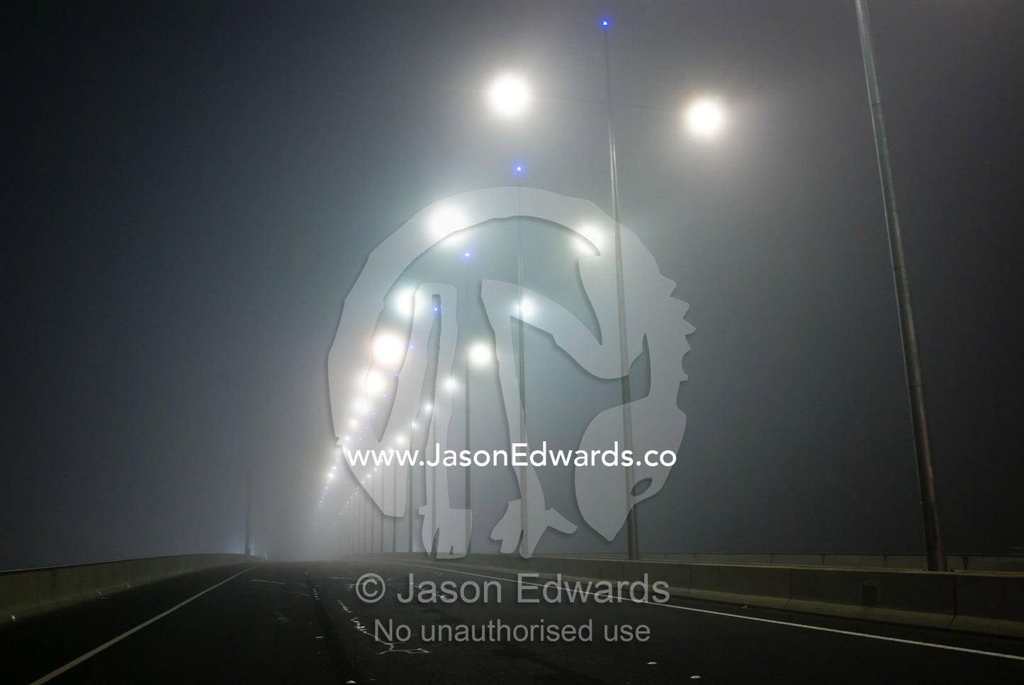 Winter fog engulfs freeway lighting on cross-town city bridge. Bolte Bridge, Yarra River, Melbourne, Victoria, Australia.