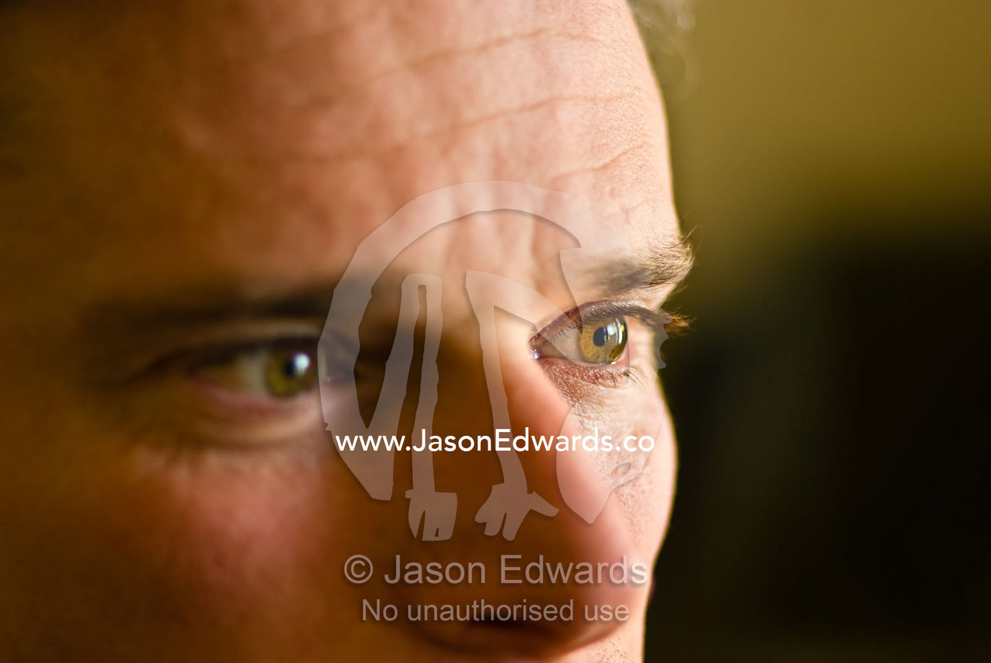 A closeup view of a man's brown eye staring out a window. Richmond, Victoria, Australia.