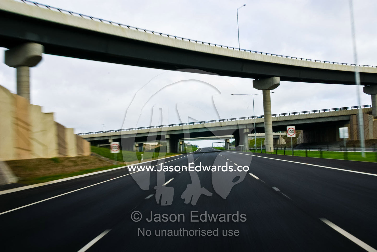 Speeding along a freeway devoid of vehicles beneath empty overpasses. Eastern and Southeastern Suburbs, Melbourne, Victoria, Australia.