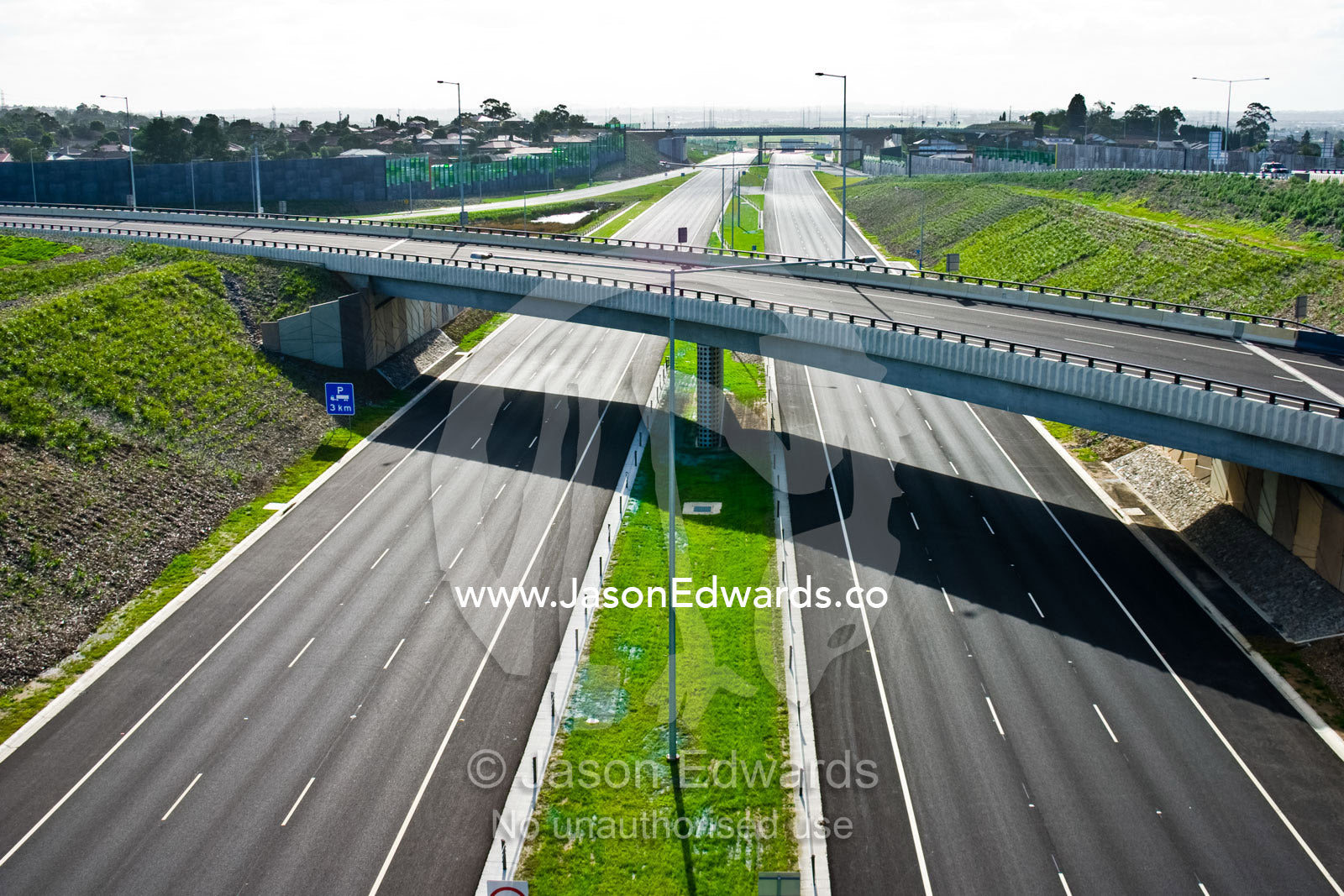 A freeway devoid of vehicles beneath empty overpasses. Eastern and Southeastern Suburbs, Melbourne, Victoria, Australia.