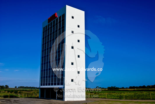 A stark white hotel that is a public art display rests in farmland. Eastern and Southeastern Suburbs, Melbourne, Victoria, Australia.