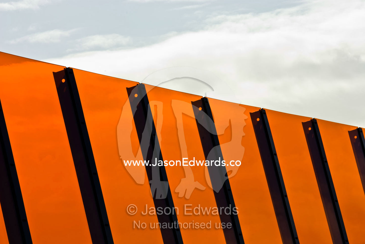 A bright orange sound barrier by a freeway. Eastern and Southeastern Suburbs, Melbourne, Victoria, Australia.