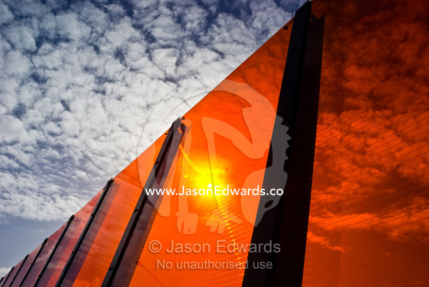 A bright orange sound barrier by a freeway. Eastern and Southeastern Suburbs, Melbourne, Victoria, Australia.