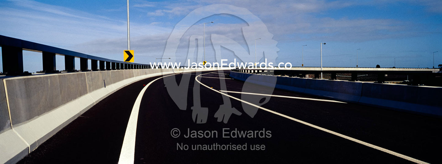 The wide curving lines of a new ultramodern freeway exit ramp. Eastern and Southeastern Suburbs, Melbourne, Victoria, Australia.