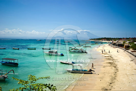 Boats moored along a tropical island beach beside a fishing village. Nusa Lembongan Island, Bali, Indonesia.