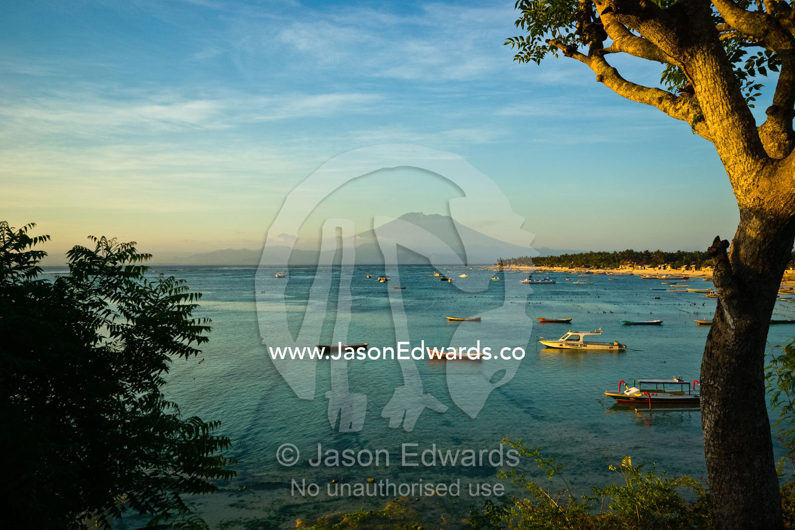 Sunset over a small tropical island bay in the shadow of Mount Agung. Nusa Lembongan Island, Bali, Indonesia.