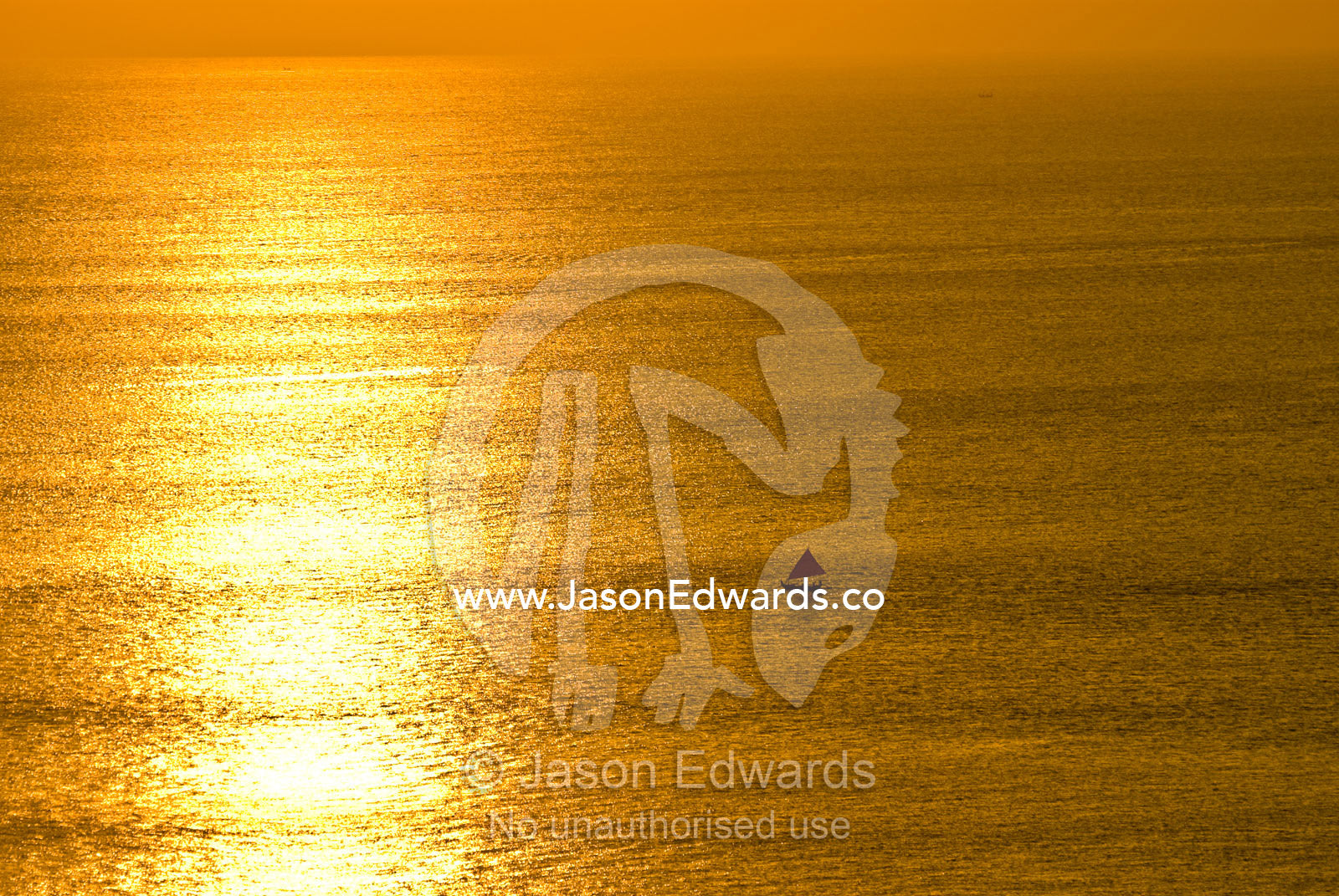 A small fishing boat heads out to sea at sunset for its nightly catch. Indian Ocean, Bukit Peninsula, Bali, Indonesia.