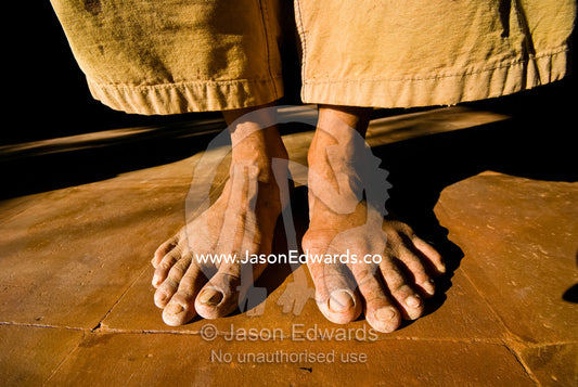 The weathered and worn feet of a laborer constructing a villa. The Temple Lodge, Bukit Peninsula, Bali, Indonesia.